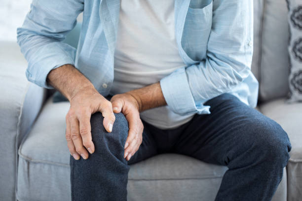 Old man suffering from knee pain stock photo