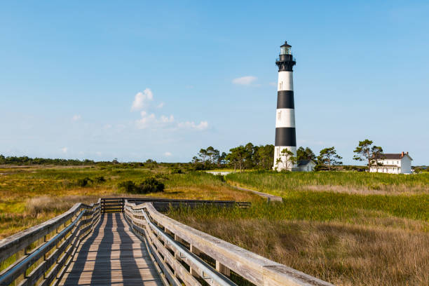 Wooden Ramp Over Marshland at Bodie Island Lighthouse Wooden ramp over marshland leading to an observation point, with the the Bodie Island lighthouse in the background, on the Outer Banks of North Carolina near Nags Head. bodie island stock pictures, royalty-free photos & images