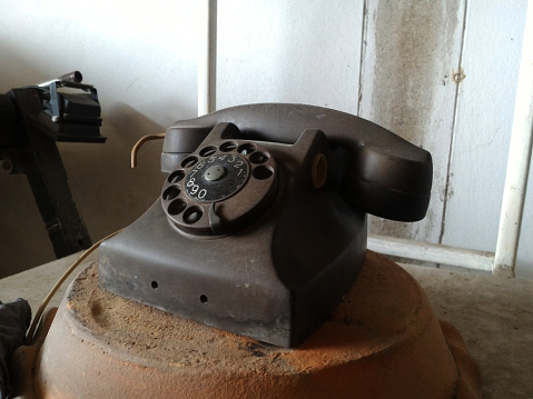 Black antique vintage analog telephone dialing or scrolling phone on wooden table,Contact us concept.