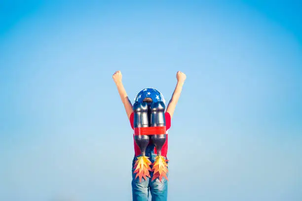 Kid with jet pack against blue sky. Child playing outdoors. Success, leader and winner concept
