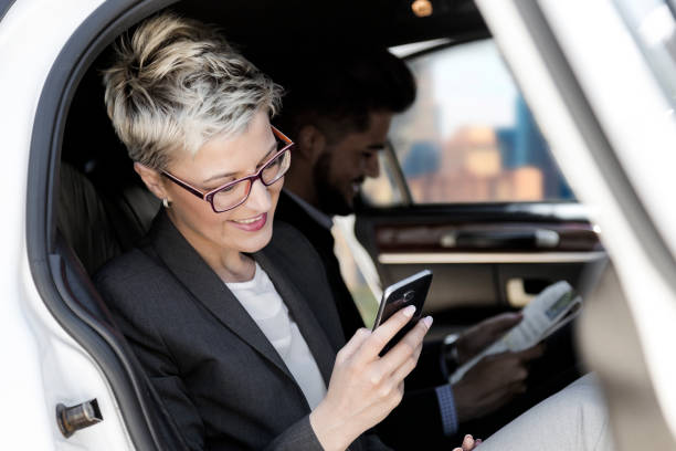 повседневная деловая поездка на лимузине - luxury car women smart phone стоковые фото и изображения