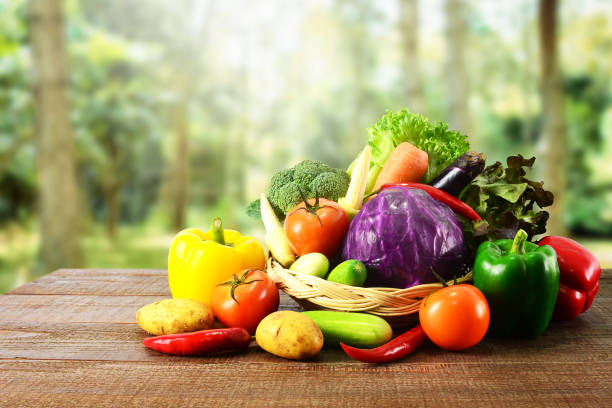 Fresh vegetables on wooden table and blurred nature background.