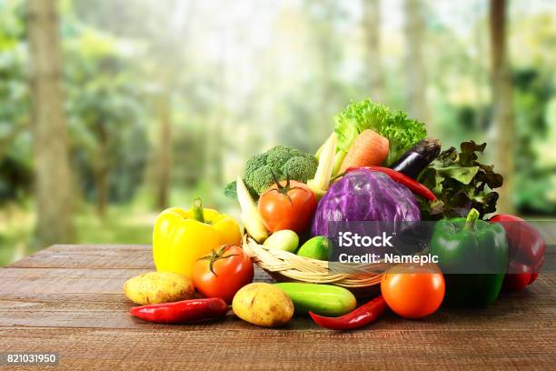 Fresh Vegetables On Wooden Table And Blurred Nature Background Stock Photo - Download Image Now