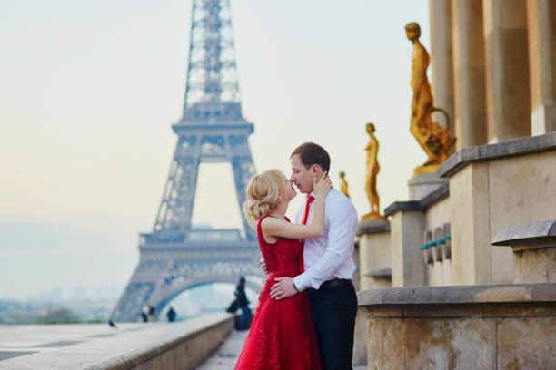 paar küssen vor eiffelturm in paris, frankreich - paris france eiffel tower love kissing stock-fotos und bilder