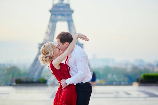 paar küssen vor eiffelturm in paris, frankreich - paris france eiffel tower love kissing stock-fotos und bilder