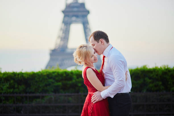 paar küssen vor eiffelturm in paris, frankreich - paris france eiffel tower love kissing stock-fotos und bilder