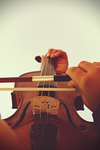 Close up of the hands playing the stringed and bowed musical instrument, the violin