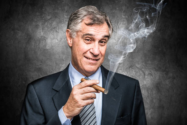 Confident senior businessman smoking a cigar stock photo
