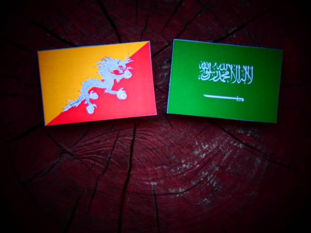 istock Bhutan flag with Saudi Arabian flag on a tree stump isolated 821043522