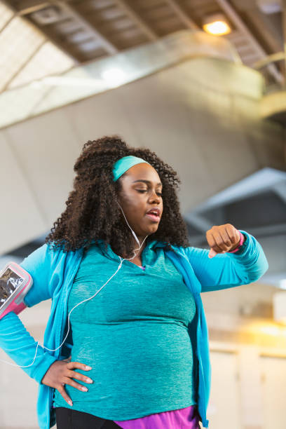 istock Young black woman exercising, using fitness tracker 821045918