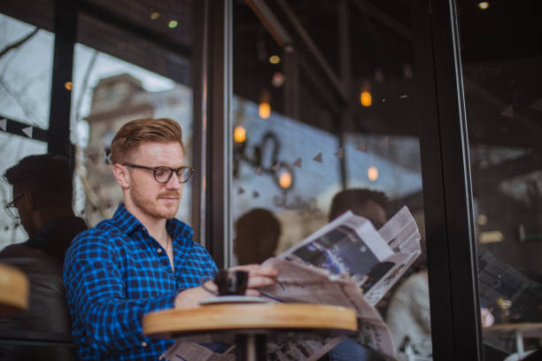 istock Man sitting in cafe and reading newspaper 821052066