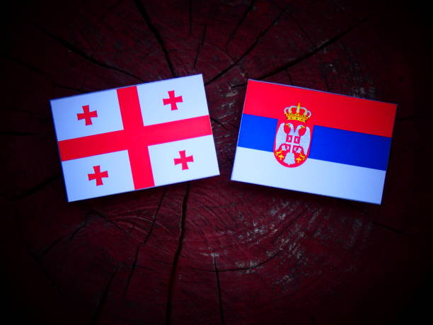 istock Georgian flag with Serbian flag on a tree stump isolated 821052150