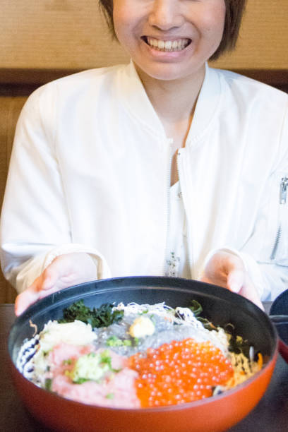 young woman eating seafood bowl