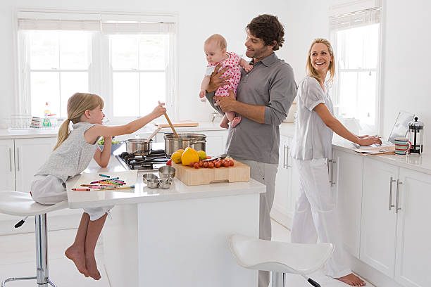 a family in a kitchen - cooking men caucasian togetherness fotografías e imágenes de stock