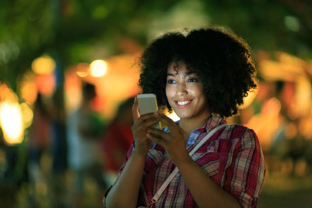 istock Smiling tourist using smart phone at night on street 821134340