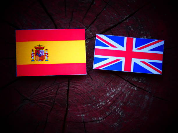 istock Spanish flag with UK flag on a tree stump isolated 821138698