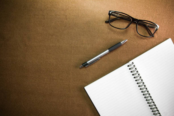 istock Business accessories on desktop: notebook,pen, glasses. With vignette 821154326