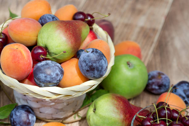 健康的な食生活の籐のバスケットに新鮮な有機フルーツ - plum fruit basket wicker ストックフォトと画像