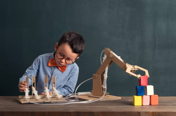 Cute child invented robot arm with cardboard.