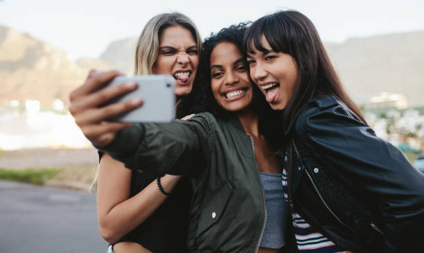 istock Smiling girls making selfie with smart phone 821169512
