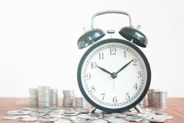 istock Stack of coins with black fashioned alarm clock for display planning money financial and business accounting concept, time is money concept with clock and coins, time to work at make money, vintage color tone 821173772