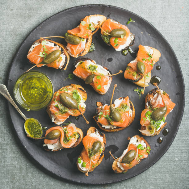 istock Homemade salmon crostini in black plate over grey background 821179330