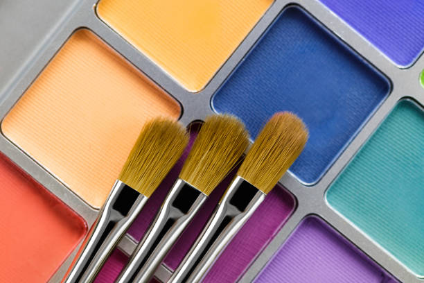 Palette of multicolored eye shadow and the makeup brush, top view