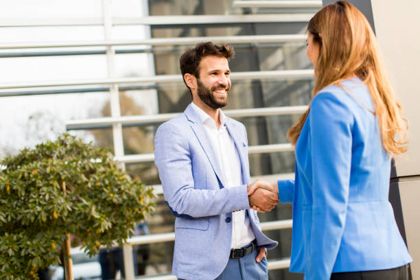 istock Business people shake hands in front of the office building 821190104