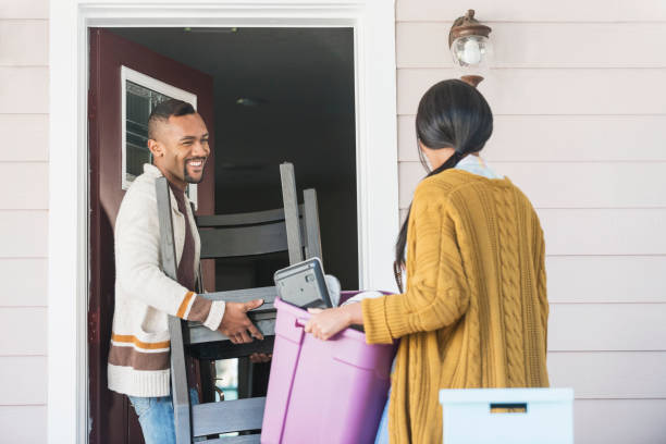 istock Young couple moving, carrying belongings thru front door 821199028