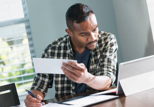 istock Young black man paying bills at home 821199432