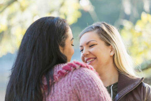 istock Lesbian couple facing each other, smiling, in the park 821202666