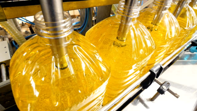 Row of plastic bottles being filled at a plant.