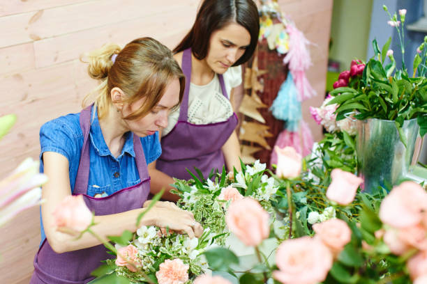 istock Girl florists working in the Studio over the bouquet 821221806