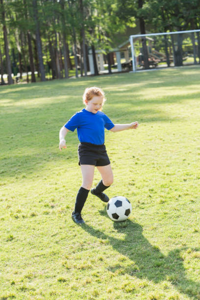 istock Girl playing soccer in the park 821234940