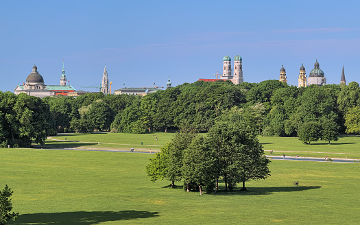 Munich, Germany - May 30, 2017: Munich skyline, view from Monopteros temple in Englischer Garten (English Garden) in summer morning, Germany. On the image shown: dome of Bavarian State Chancellery, tower of St. Peter Church, tower of New Town Hall, Frauenkirche (Cathedral of Our Lady), Theatinerkirche (Theatine Church of St. Cajetan).