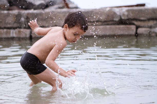 istock Boy plays with water on the sea 821250954