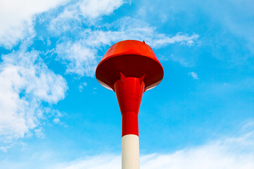 Red and white steel water tank, sky background