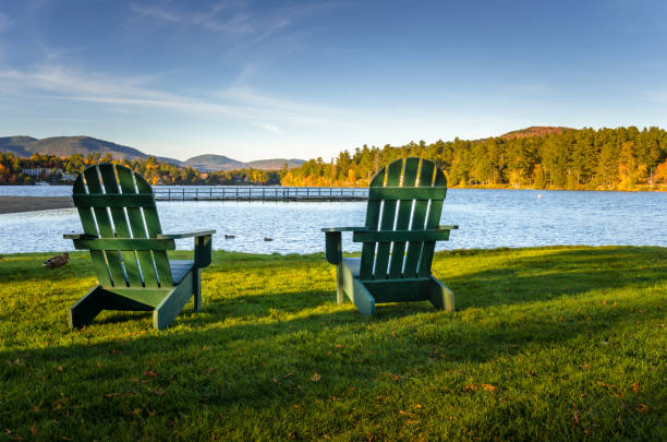 chaises adirondack face à un lac de montagne, sous un ciel dégagé - autumn sky nobody lake photos et images de collection