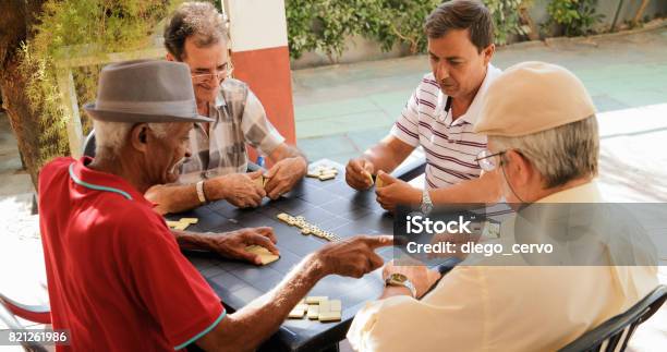 Active Retirement Happy Old Friends Playing Domino Game Stock Photo - Download Image Now