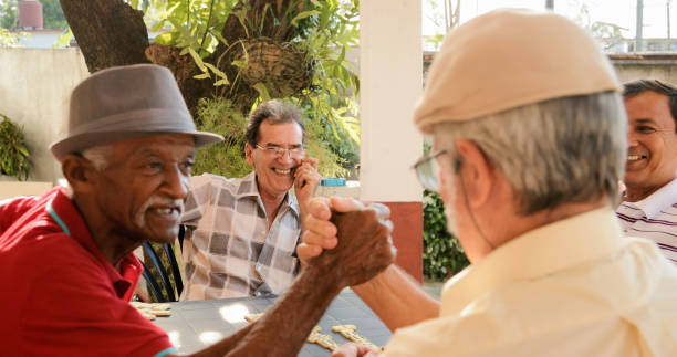 istock Old Men Shaking Hands Winning Game Of Domino 821264176