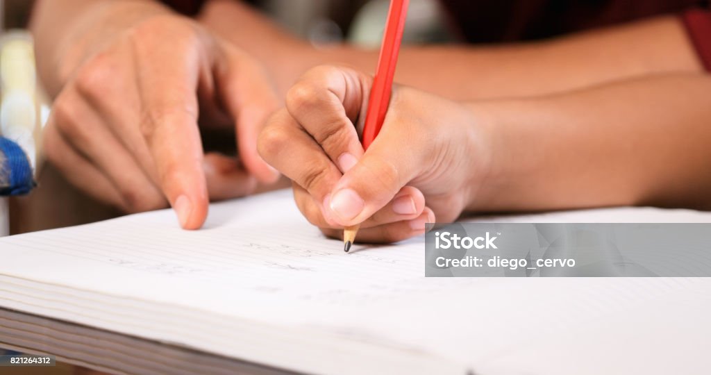 Elementare Mädchen Hausaufgaben abgeben auf Schulheft zu schreiben - Lizenzfrei Nachhilfelehrer Stock-Foto