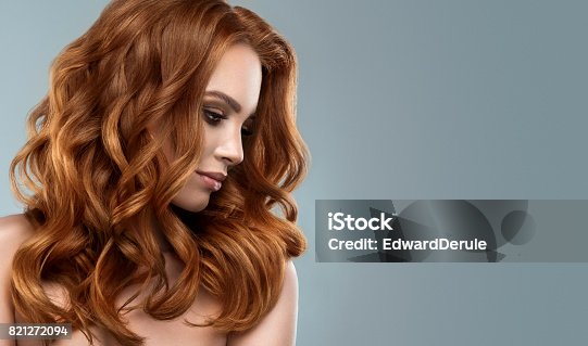 istock Red haired woman with voluminous, shiny and curly hairstyle.Flying hair. 821272094