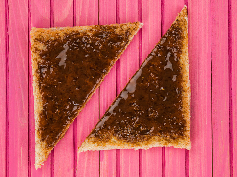Beef Extract Spread on Toast Against a Pink Wooden Background