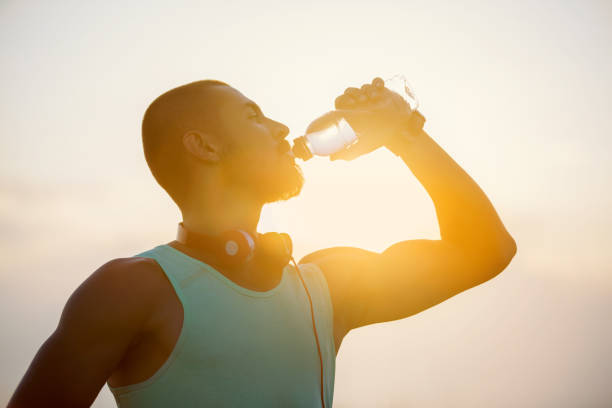 istock Photo of a young man drinking water at sunset 821302716