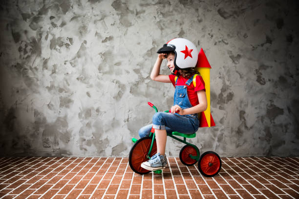 Child riding a retro bicycle Child with cardboard rocket riding a retro bicycle. Kid having fun at home. Travel and vacation concept super bike stock pictures, royalty-free photos & images