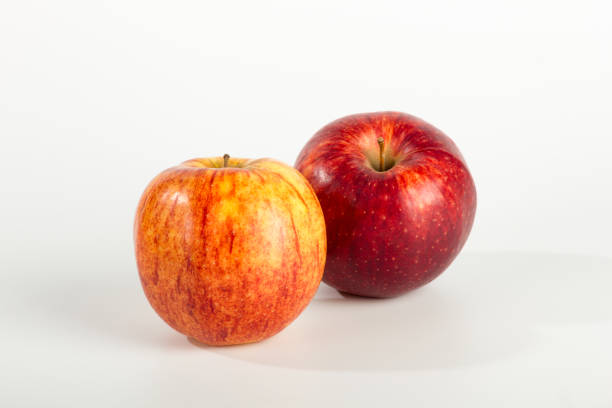 un paio di mele su sfondo bianco chiaro - jonathan apple foto e immagini stock