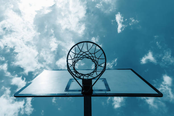 basketball backboard on blue cloudy sky background, Outdoor basketball hoop on a cloudy day
