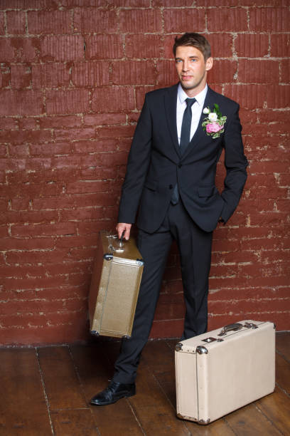 istock groom is a brick wall with suitcases 821346824