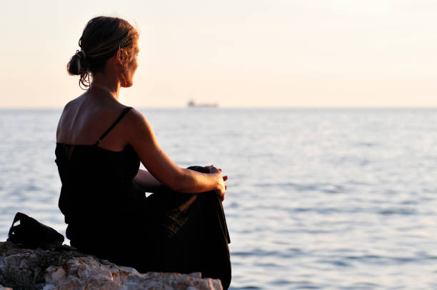 istock Girl meditating on the beach 821350306