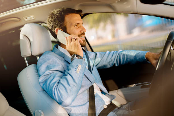 istock Handsome man driving a car and using smartphone 821359150